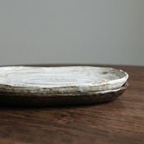 Round ceramic plate on a wooden surface with a gray background