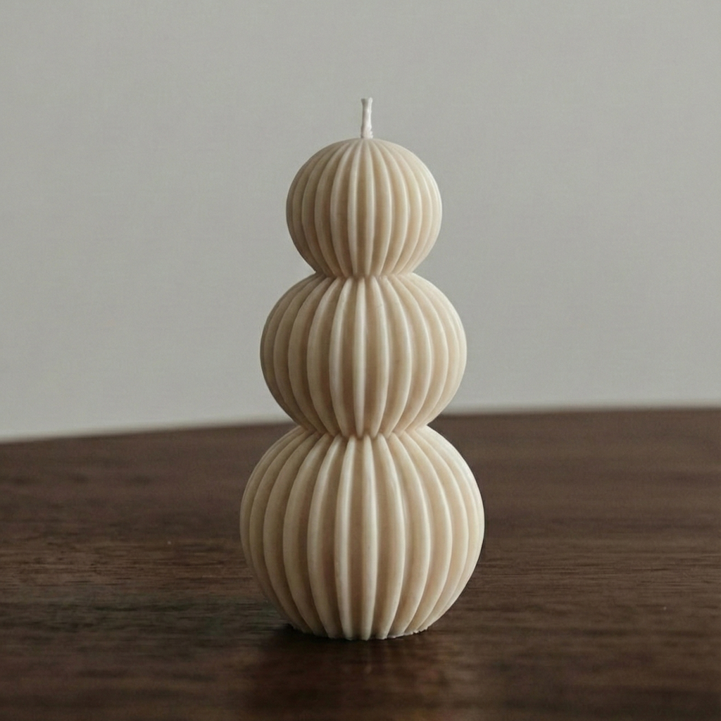 Decorative candle with ribbed texture on a wooden surface