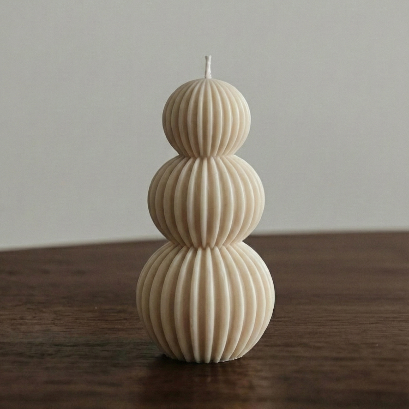 Decorative candle with ribbed texture on a wooden surface