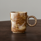 Brown ceramic mug on a wooden surface with a gray background