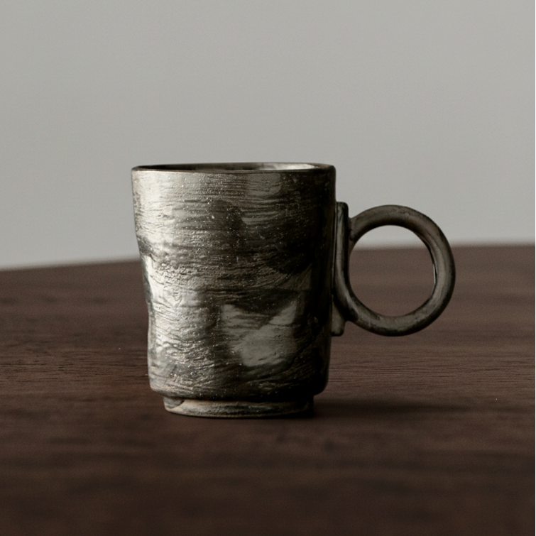 Ceramic mug with a textured surface on a wooden surface